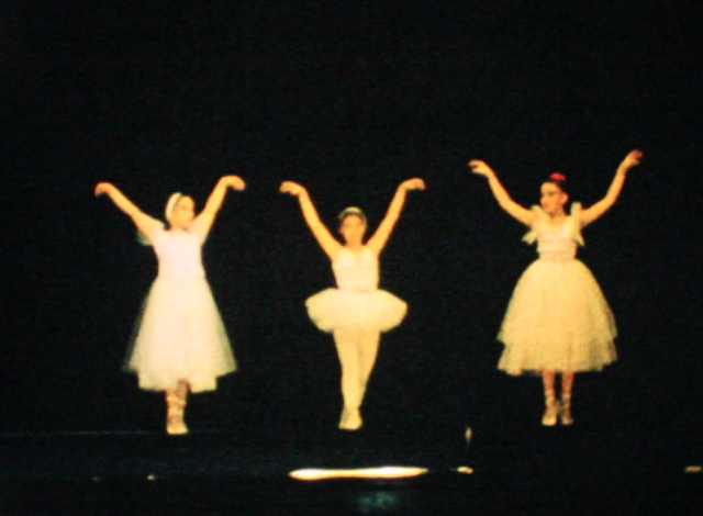 Niños representa una obra de teatro en un escenario. En otra secuencia dos niñas bailan mientras son filmadas desde una posición elevada.
